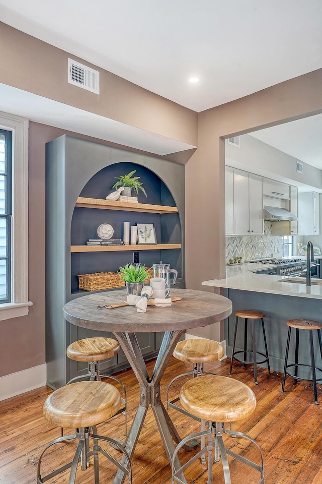 dining area featuring visible vents, baseboards, and wood finished floors