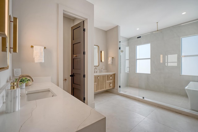 bathroom with recessed lighting, a stall shower, two vanities, and a sink