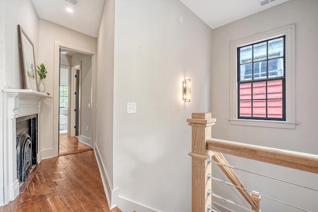 hallway with visible vents, baseboards, and wood-type flooring