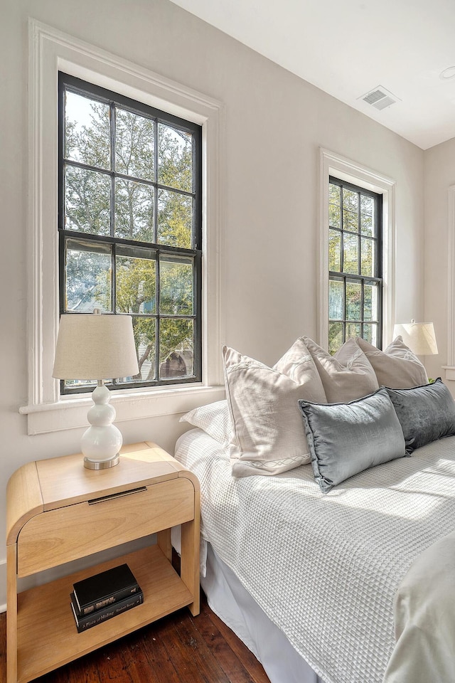 bedroom with visible vents and dark wood-type flooring