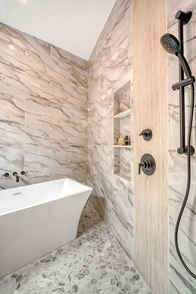 full bath with a freestanding tub, tile walls, and a tile shower