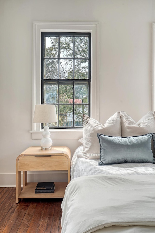 bedroom with baseboards and wood finished floors