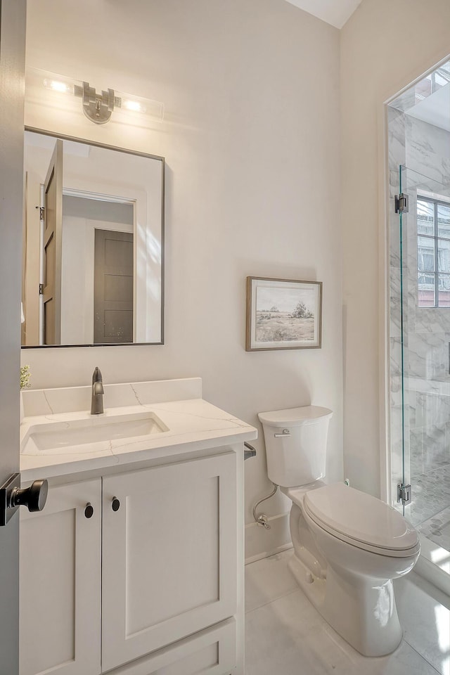 bathroom featuring baseboards, vanity, toilet, and a shower stall