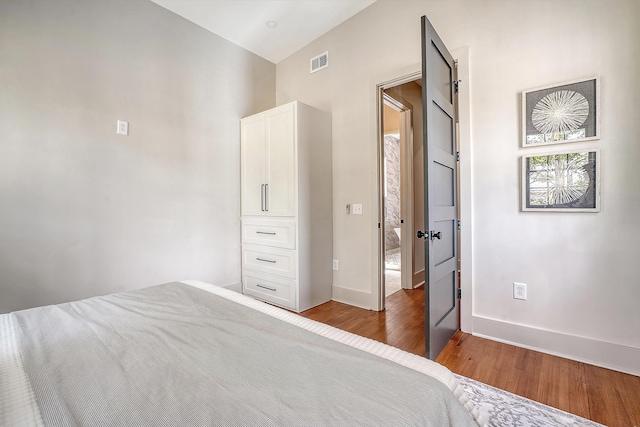 unfurnished bedroom featuring visible vents, baseboards, and wood finished floors