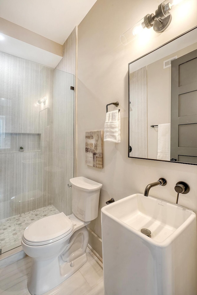 bathroom with visible vents, baseboards, toilet, and a shower stall