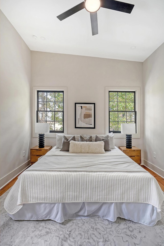 bedroom with wood finished floors, baseboards, and ceiling fan