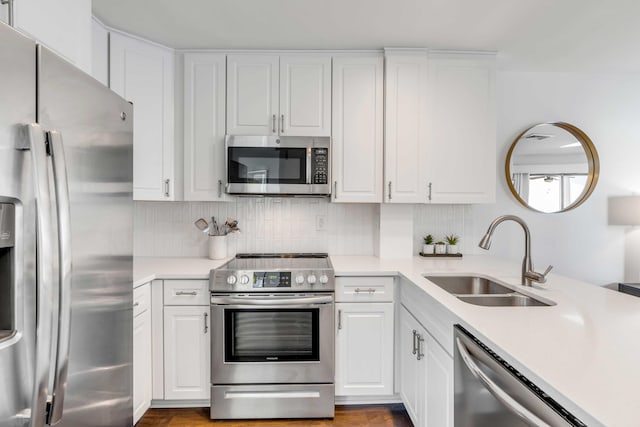 kitchen featuring a sink, light countertops, backsplash, and stainless steel appliances