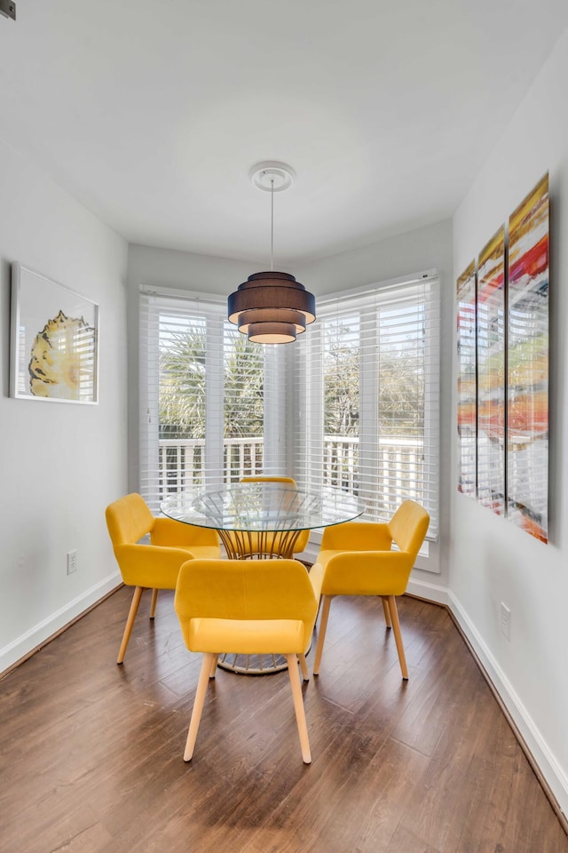 dining space featuring wood finished floors and baseboards