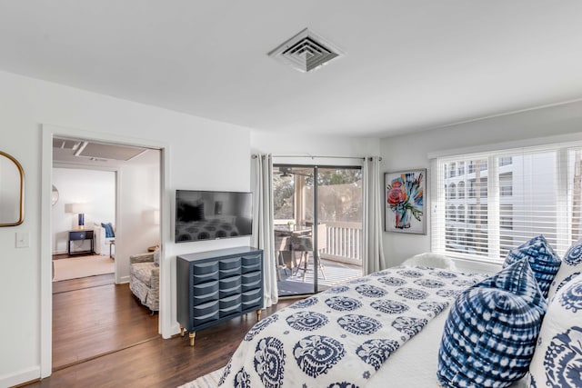 bedroom featuring access to exterior, visible vents, baseboards, and wood finished floors