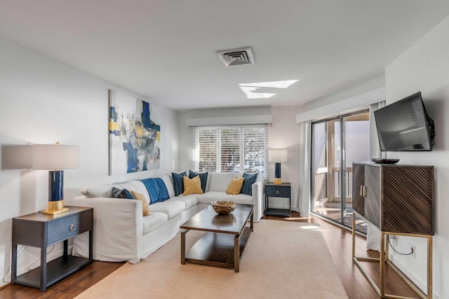 living area with visible vents and wood finished floors