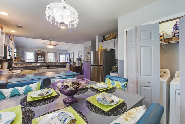 8059 Shadow Oak Dr, North Charleston, SC 29406 - dining space with washer and clothes dryer, lofted ceiling, a ceiling fan, and a chandelier