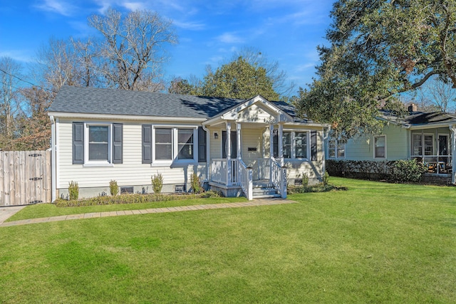 view of front facade featuring a front lawn, roof with shingles, and fence