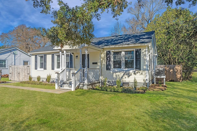 bungalow-style home featuring a shingled roof, a front yard, and fence