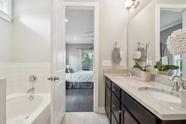 bathroom featuring ornamental molding, vanity, hardwood / wood-style floors, and a bathing tub