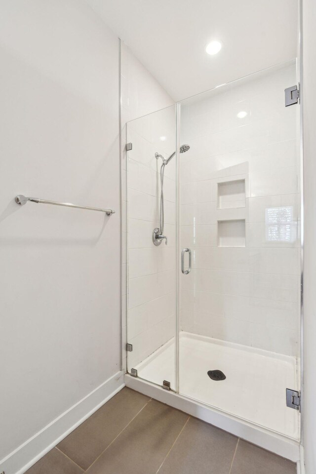 bathroom with tile patterned flooring and a shower with door