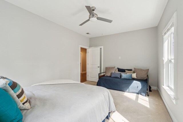 carpeted bedroom featuring multiple windows and ceiling fan