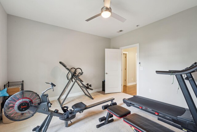 exercise area featuring light carpet and ceiling fan