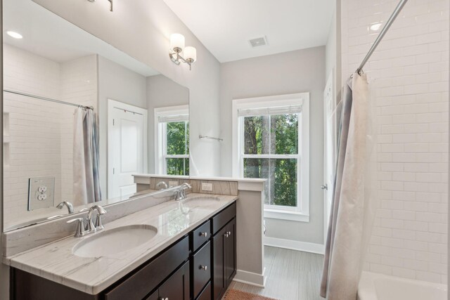 bathroom featuring shower / bath combo, hardwood / wood-style flooring, and vanity