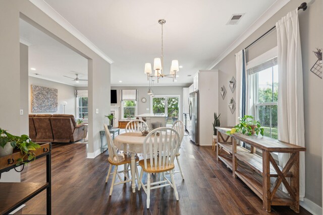 dining space with ceiling fan with notable chandelier, ornamental molding, and dark hardwood / wood-style flooring