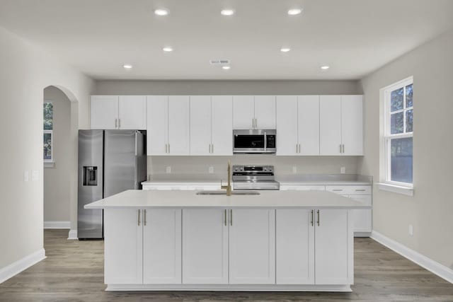 5629 Ellington School Rd, Ravenel, SC 29470 - kitchen featuring stainless steel appliances, a sink, arched walkways, baseboards, and light countertops