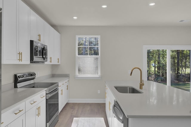 5629 Ellington School Rd, Ravenel, SC 29470 - kitchen featuring appliances with stainless steel finishes, a sink, a center island with sink, wood finished floors, and light countertops