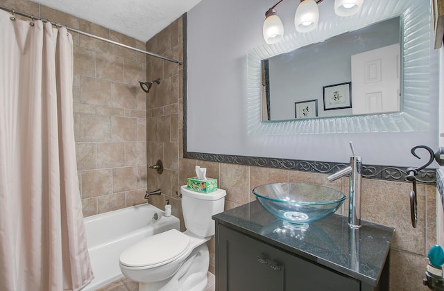 full bathroom featuring vanity, tile walls, toilet, a wainscoted wall, and shower / bath combination with curtain