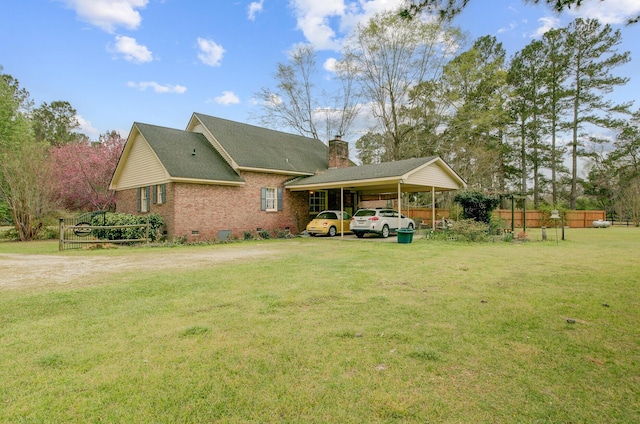 rear view of house with a lawn, crawl space, brick siding, an attached carport, and a chimney