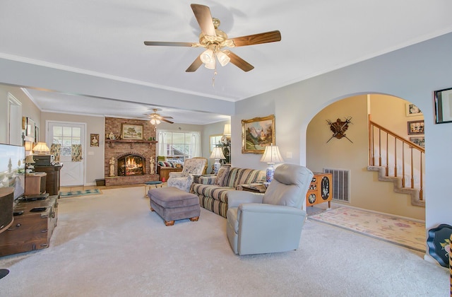 living area featuring a wealth of natural light, visible vents, ornamental molding, and carpet