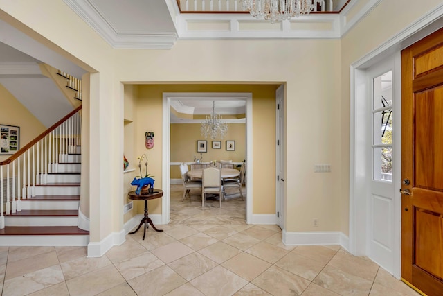 entrance foyer with a chandelier, stairway, baseboards, and crown molding