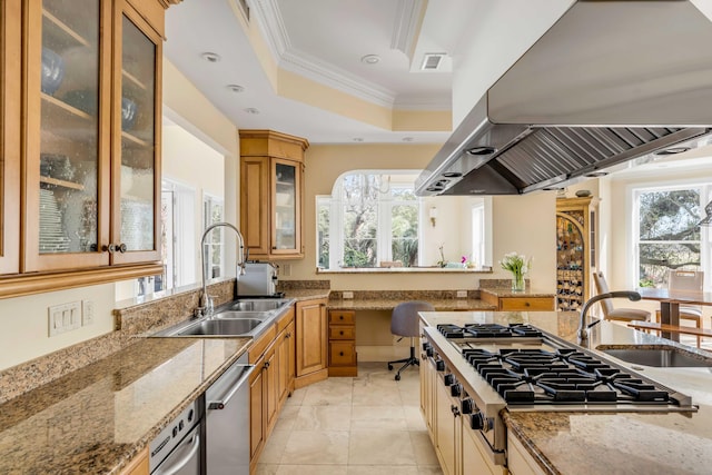 kitchen featuring a sink, light stone countertops, glass insert cabinets, and island range hood