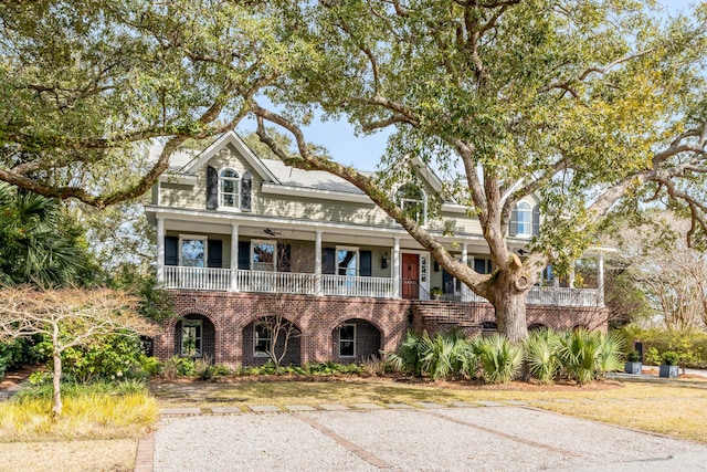 view of front facade featuring covered porch and brick siding