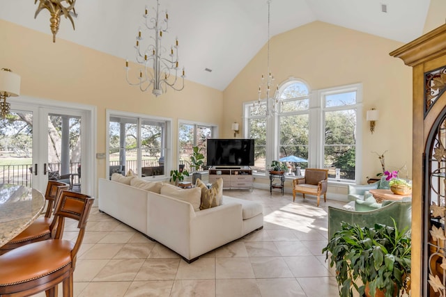 living area featuring a chandelier, high vaulted ceiling, light tile patterned floors, and a healthy amount of sunlight