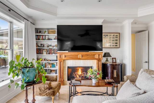 living area featuring a high end fireplace, a tray ceiling, and light tile patterned floors