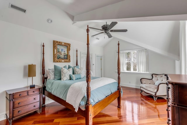 bedroom with baseboards, visible vents, ceiling fan, wood finished floors, and vaulted ceiling