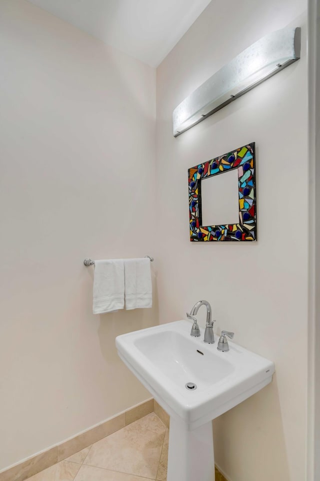 bathroom with a sink, tile patterned flooring, and baseboards