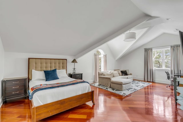 bedroom featuring baseboards, vaulted ceiling, and wood finished floors