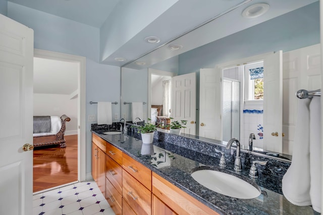 ensuite bathroom with tile patterned floors, a sink, ensuite bath, and double vanity