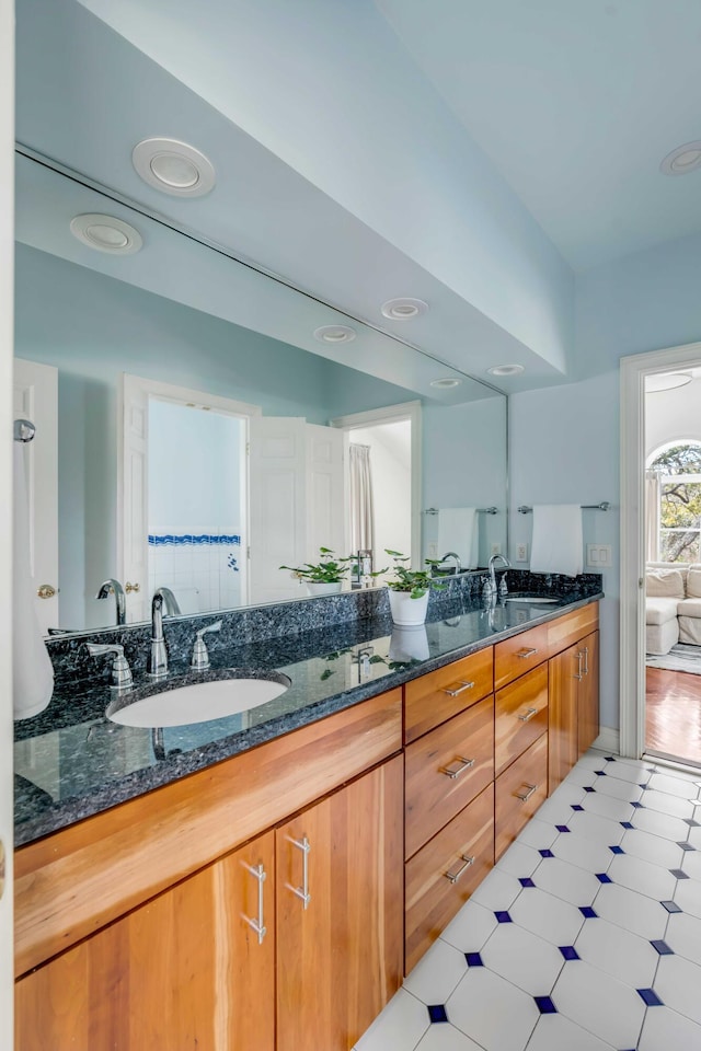 full bath featuring double vanity, a sink, and tile patterned floors