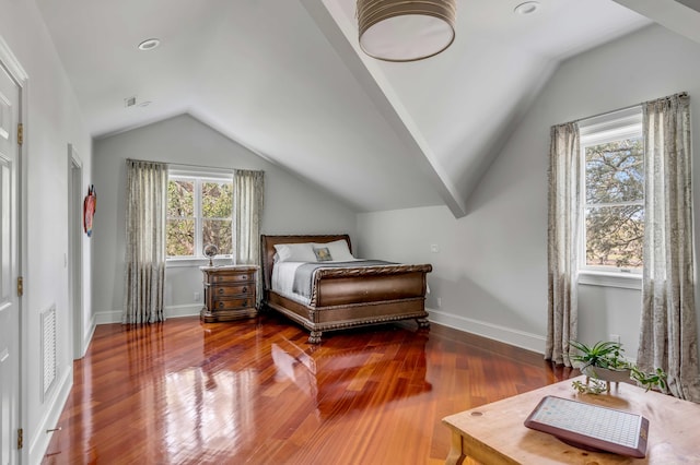 bedroom with lofted ceiling, visible vents, baseboards, and wood finished floors