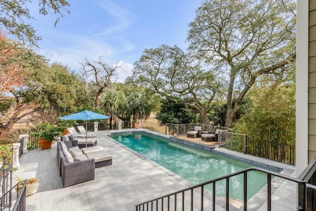 view of pool featuring a patio area, fence, an outdoor living space, and a fenced in pool