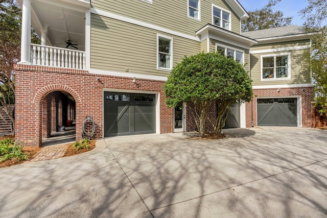 view of front facade with an attached garage, a balcony, concrete driveway, and brick siding