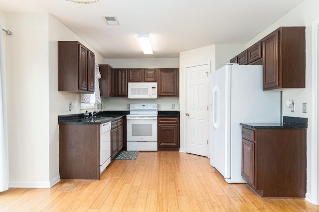kitchen with white appliances, light hardwood / wood-style floors, dark brown cabinetry, and sink
