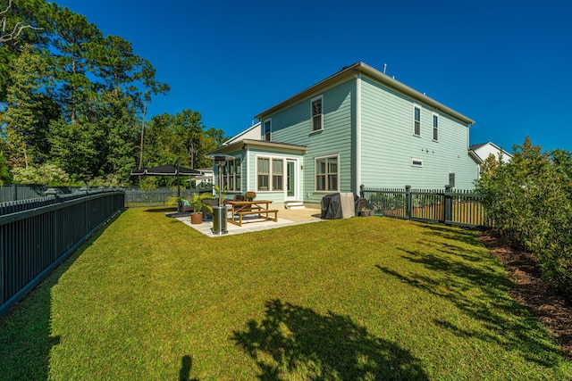 rear view of property with a patio and a lawn