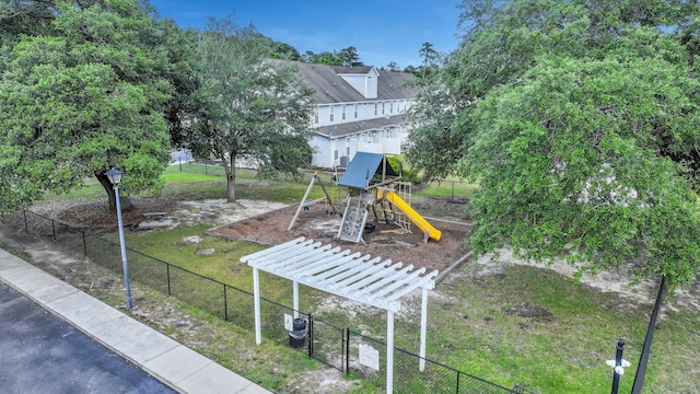 exterior space featuring fence, a lawn, a pergola, and a playground