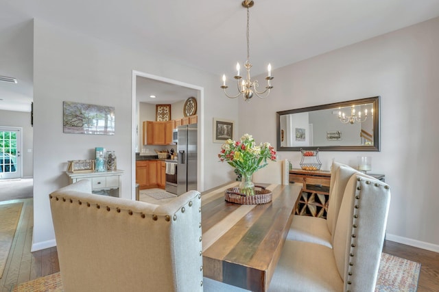 dining room with an inviting chandelier, light wood-style flooring, and baseboards