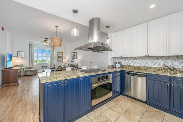 kitchen with blue cabinets, sink, ceiling fan, appliances with stainless steel finishes, and island exhaust hood