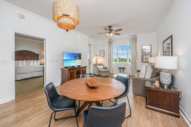 dining area featuring ceiling fan, light wood-type flooring, and ornamental molding