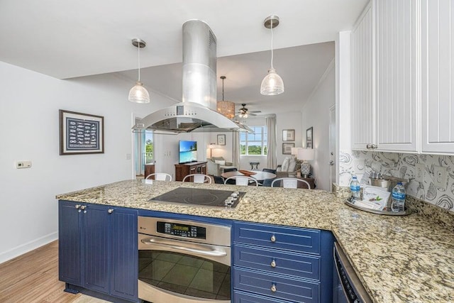 kitchen featuring black electric stovetop, stainless steel oven, blue cabinets, and island range hood