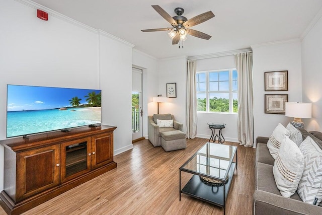 living room with light wood-type flooring, ceiling fan, and ornamental molding