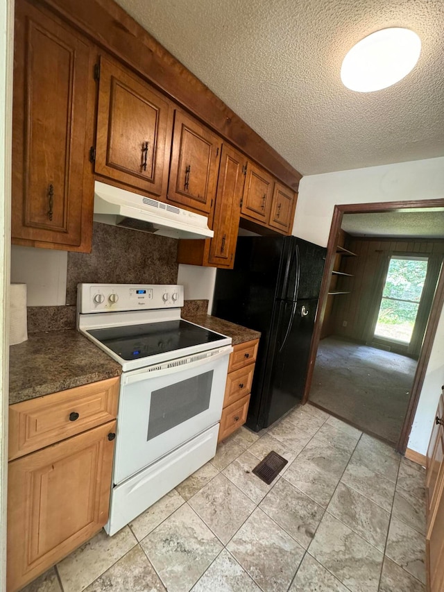 kitchen featuring white range with electric stovetop, black refrigerator, and a textured ceiling